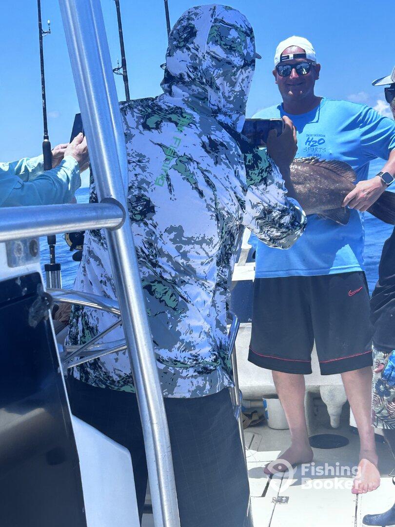 A group of anglers celebrating a successful catch aboard a fishing boat, with one person proudly displaying a large fish.