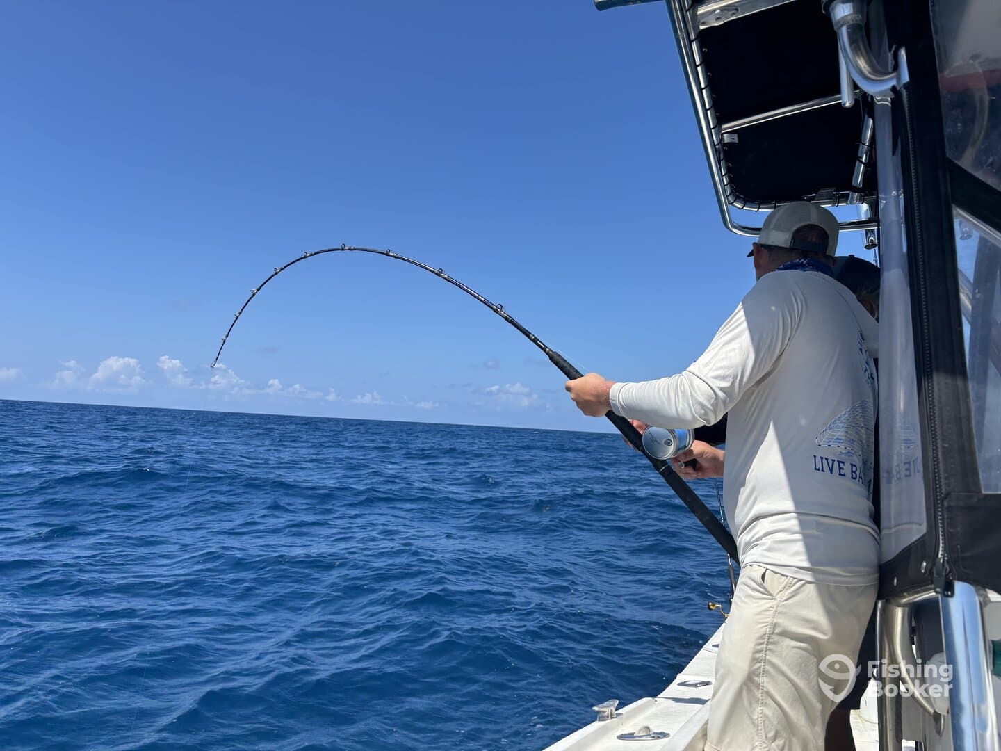 Angler reeling in a catch while fishing offshore, showcasing the excitement of deep-sea fishing.