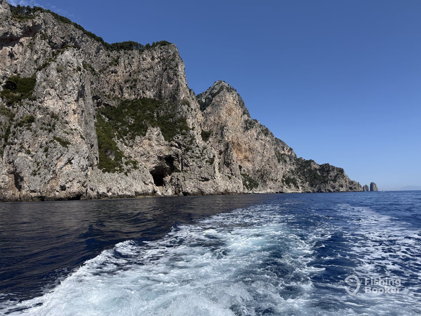Scenic view of rugged cliffs along the coastline, captured from a boat, showcasing the beautiful marine environment.