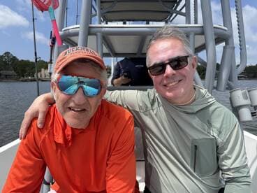 Two anglers enjoying a moment on the boat, showcasing a relaxed atmosphere on a fishing trip.