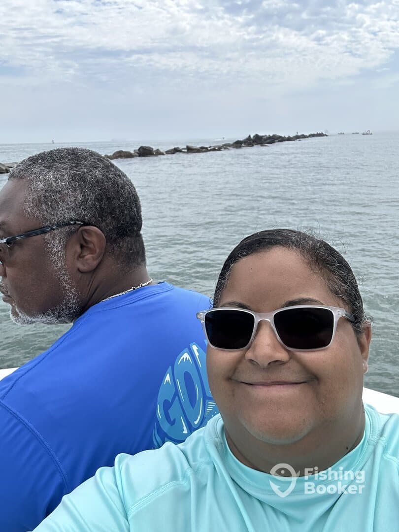 Two anglers enjoying a day on the water, with a scenic backdrop of the coastline.