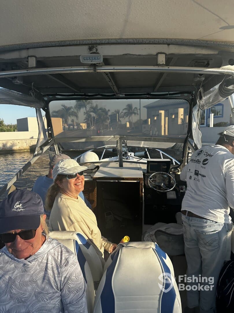 Passengers enjoying the ride on a fishing boat, with a view of the helm and surrounding scenery.