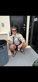 A young man relaxing inside the boat, seated near the entrance with a drink in hand, showcasing a casual fishing trip atmosphere.