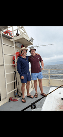 Two anglers enjoying a day on the boat, showcasing a relaxed fishing atmosphere.