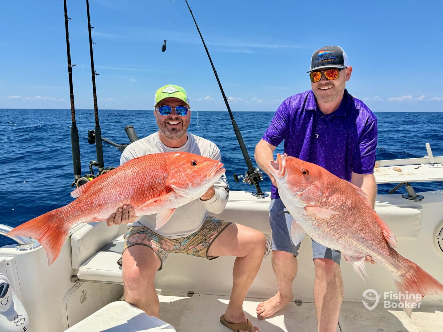Two anglers proudly displaying their large Red Snapper catches while fishing offshore, showcasing a successful day on the water.