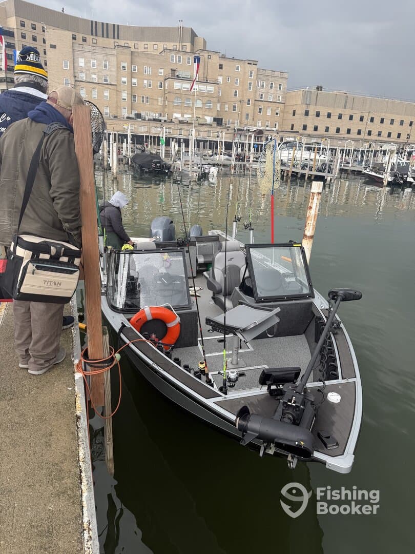 A group of anglers preparing to board a sleek fishing boat at the marina, showcasing the boat's exterior and fishing gear.