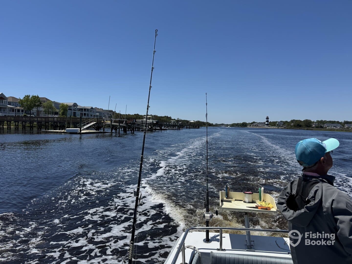 A young angler enjoying a scenic boat ride along the waterfront, with fishing rods ready for action.