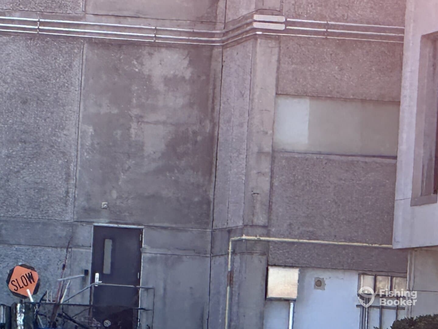 An unclear image showing a building exterior with no visible fishing elements.