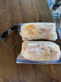 Two bags of freshly filleted fish laid out on a table, showcasing the catch from a recent fishing trip.