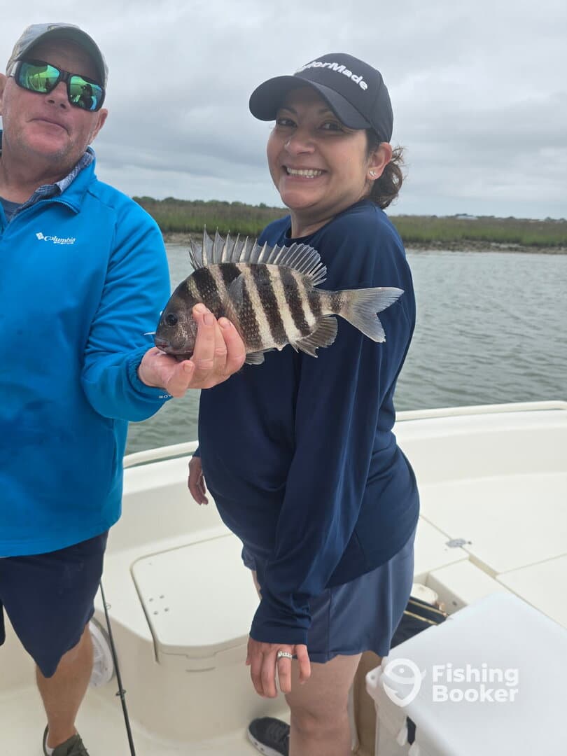 Two anglers proudly displaying a Sheepshead caught while fishing on a boat, showcasing a fun day on the water.