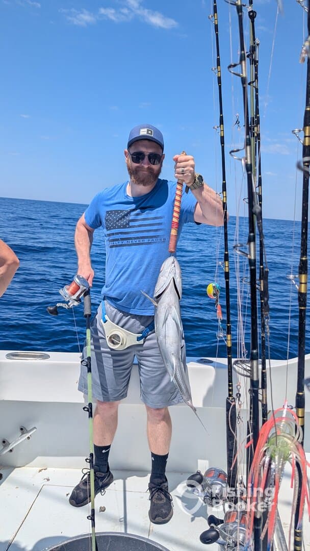 Angler proudly displaying a large fish while fishing offshore, showcasing a successful day on the water.