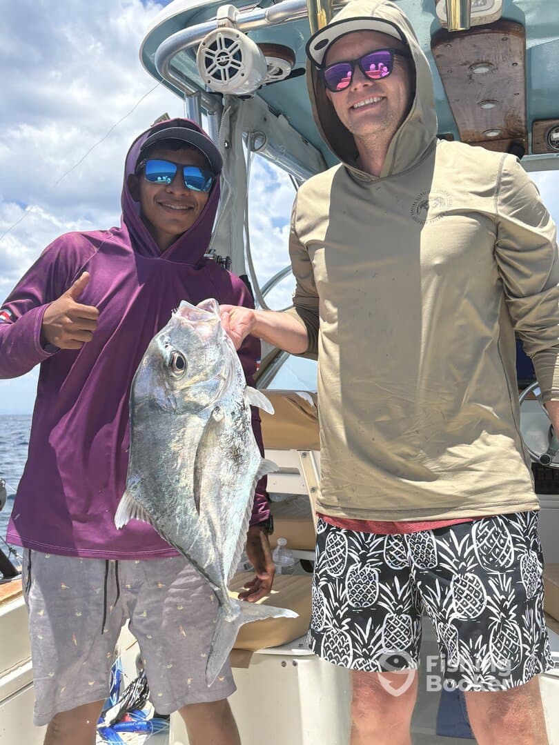 Two anglers proudly displaying a large fish on a boat during a fishing trip.