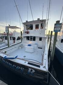 The exterior view of the 'Chances R' fishing charter boat docked at a marina, showcasing its spacious deck and amenities.
