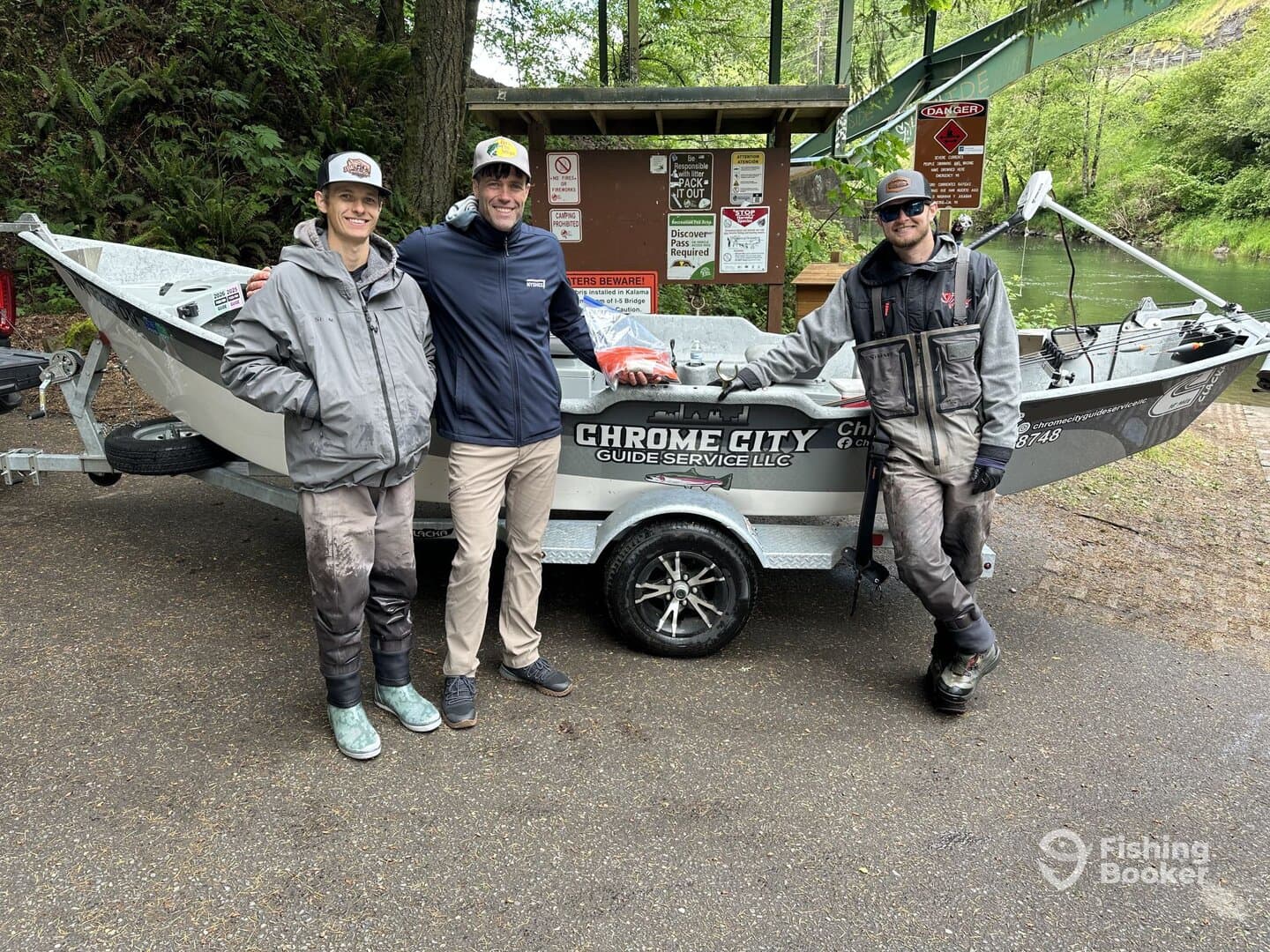 Three anglers pose beside a sleek fishing boat from Chrome City Guide Service, showcasing their readiness for a day on the water.