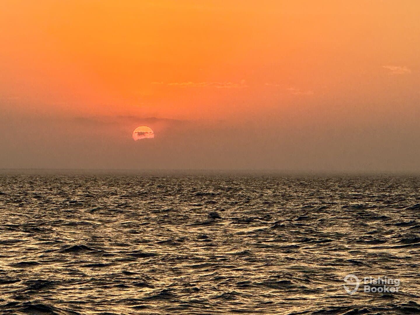 A serene sunset over the ocean, creating a beautiful backdrop for a fishing trip.