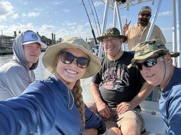 A cheerful group of anglers enjoying a day on the boat, showcasing camaraderie and excitement for their fishing adventure.