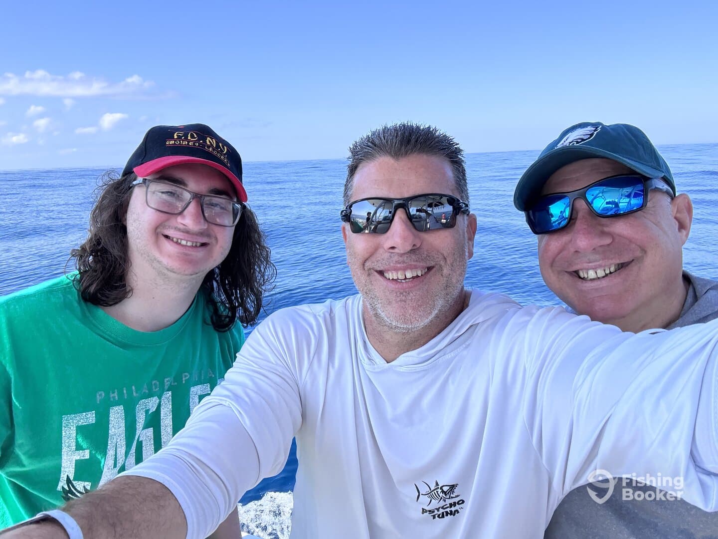 Three anglers enjoying a sunny day on the water, capturing a selfie while fishing.