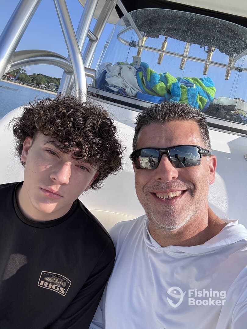 A father and son enjoying a day on the boat, capturing a moment together with the scenic backdrop of the water.