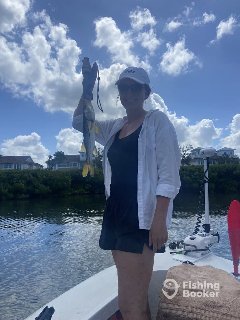 A proud angler holding a vibrant Snook while enjoying a sunny day on the water.