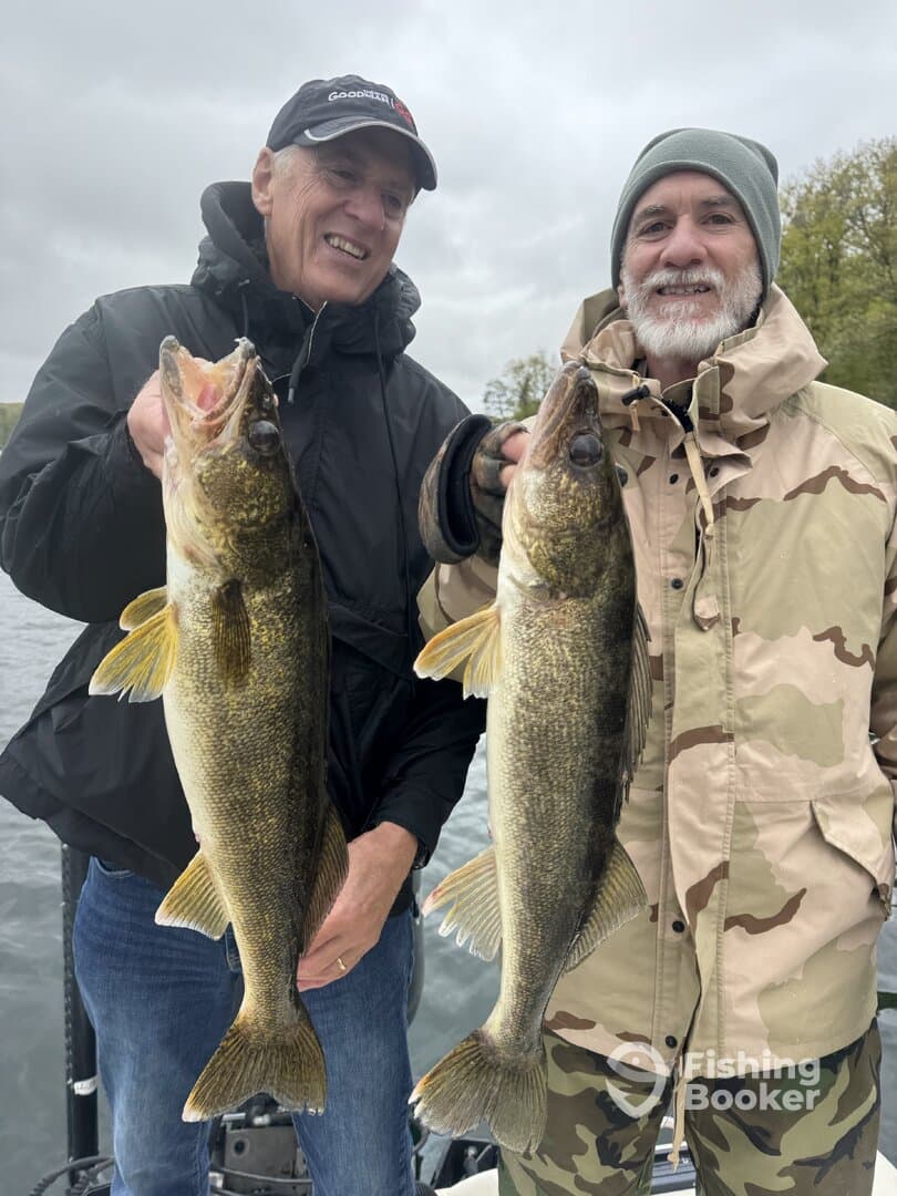 Two anglers proudly displaying their catch of Walleye while fishing on a cloudy day.