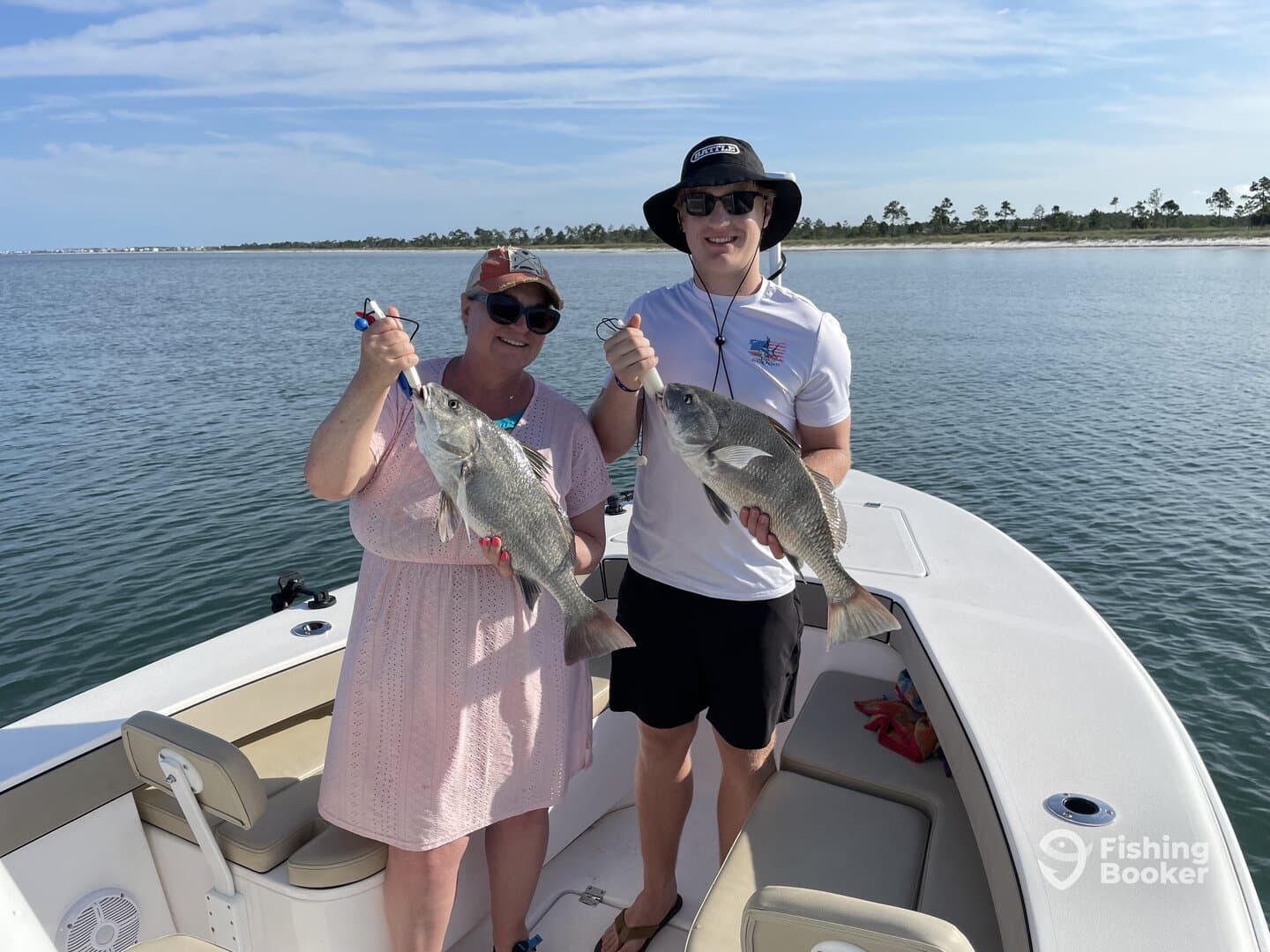 Two anglers proudly displaying their catches of Black Drum while enjoying a sunny day on the water.