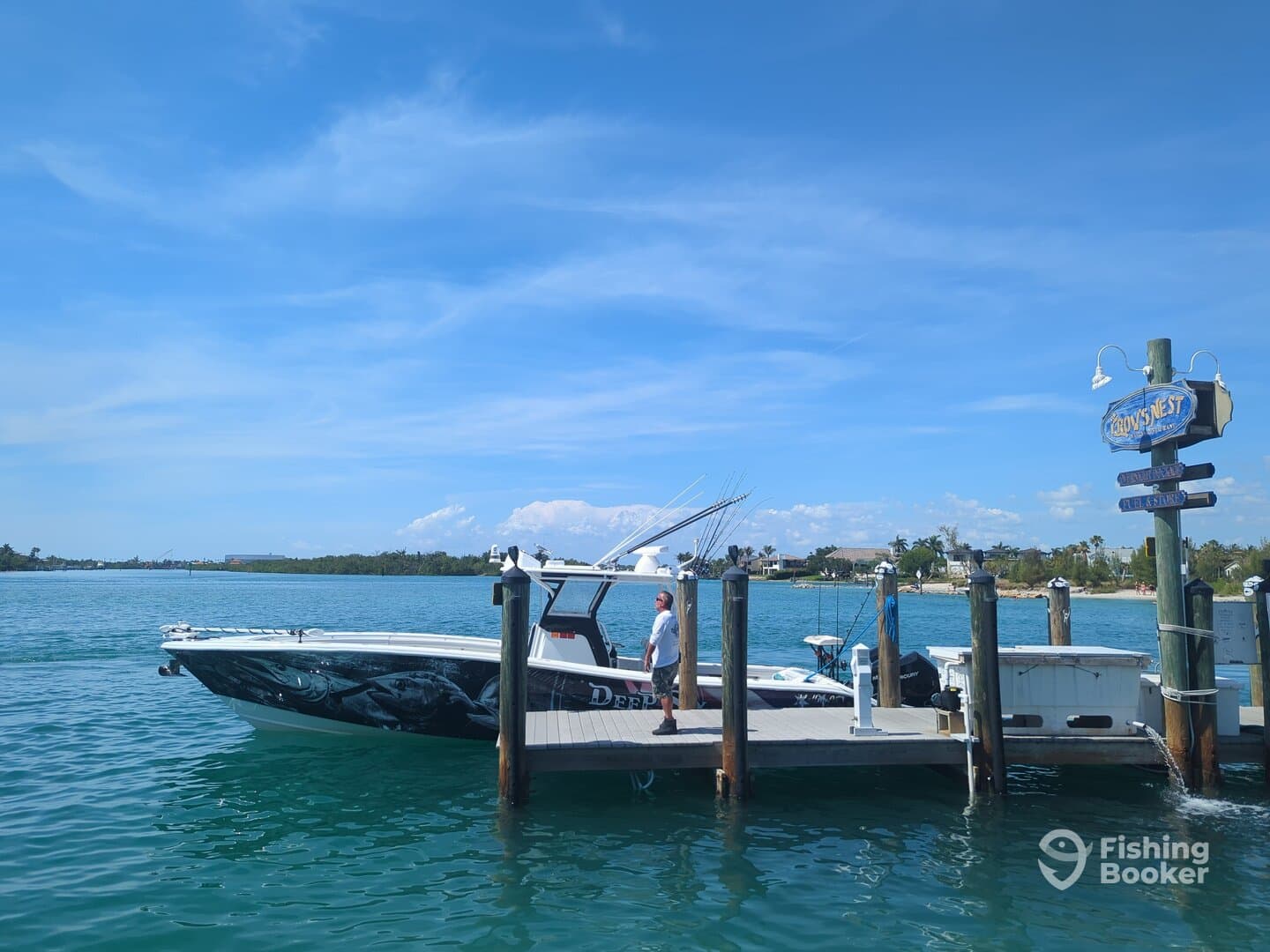 A sleek fishing boat docked at a marina, showcasing its unique design against a clear blue sky.