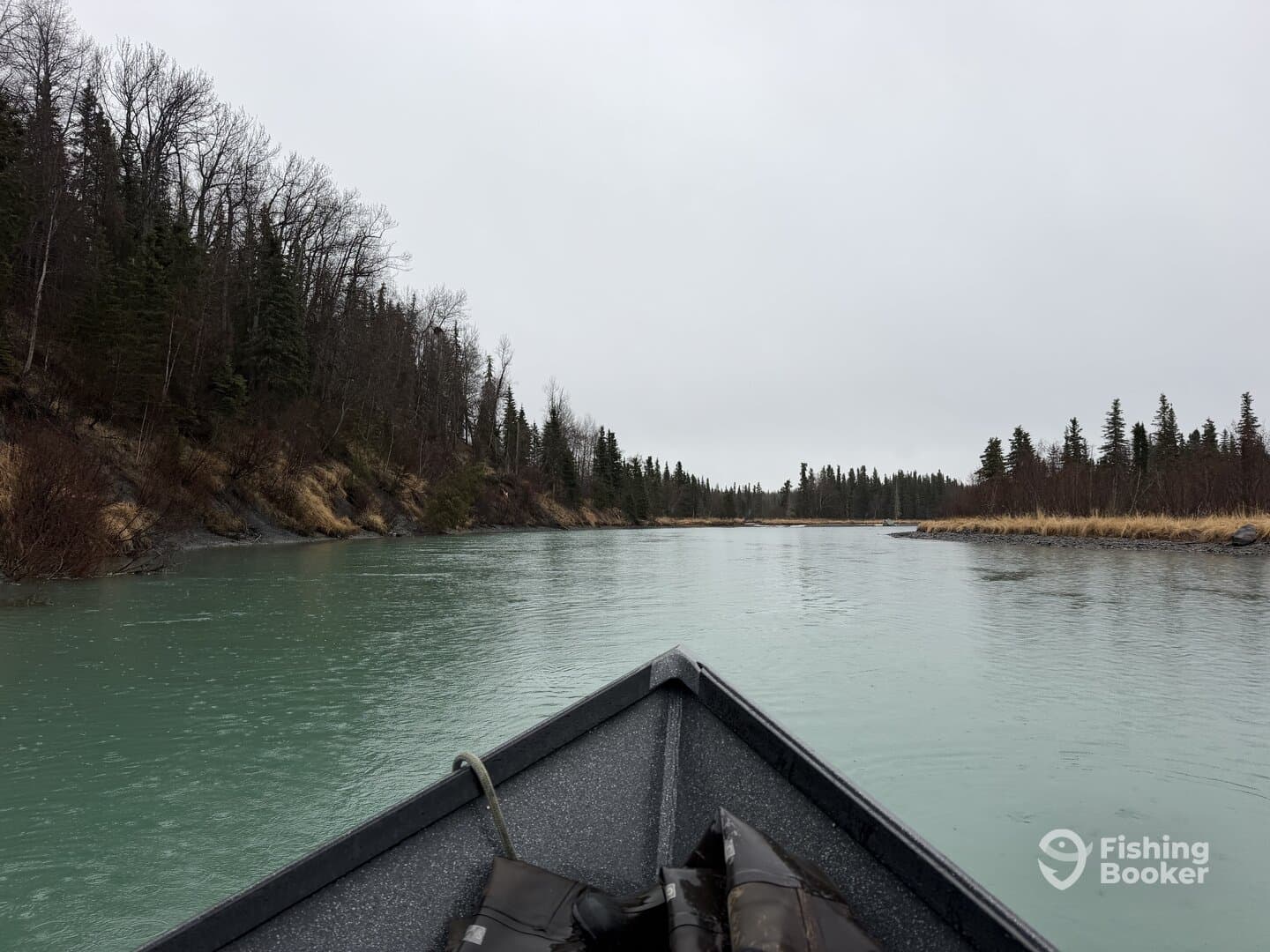 A scenic view from the front of a fishing boat navigating a tranquil river surrounded by lush greenery and trees, ideal for fishing adventures.