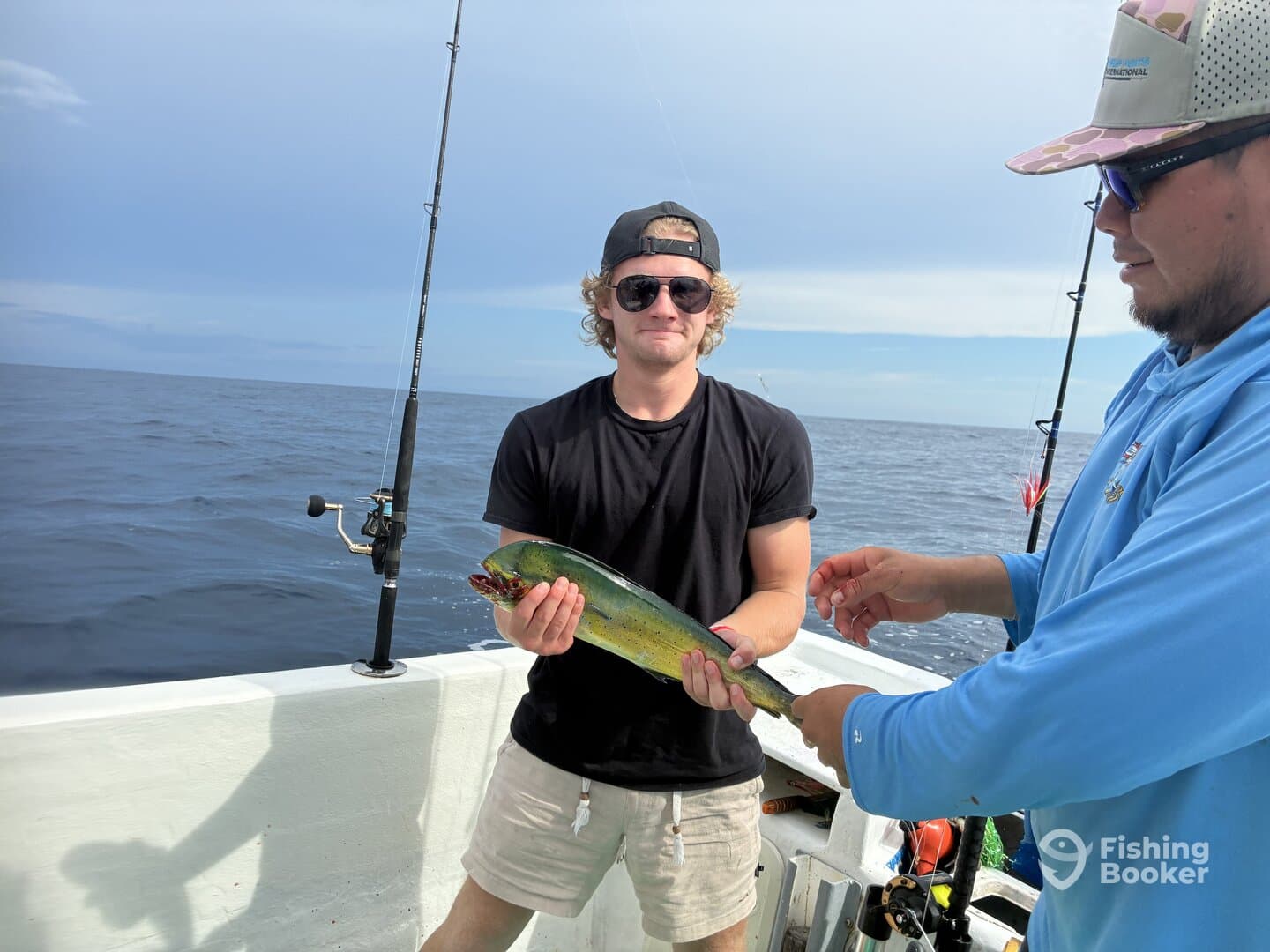 A young angler proudly displaying a vibrant Mahi Mahi while fishing offshore, showcasing the excitement of the catch.