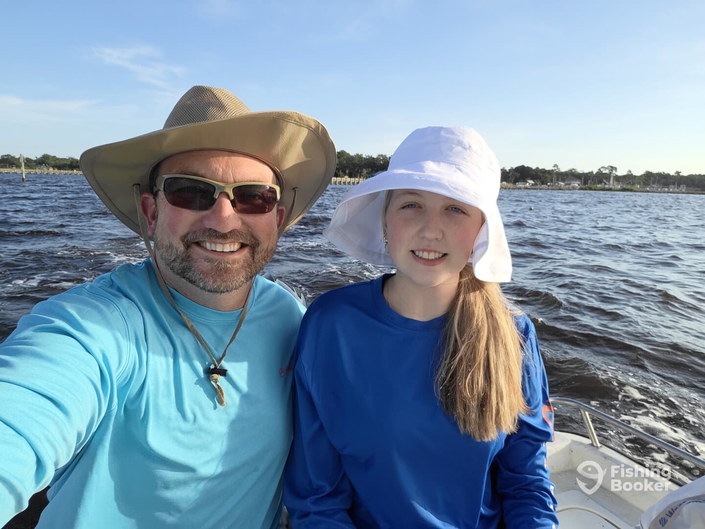A smiling adult and a young girl enjoying a day on the water, likely preparing for a fishing trip.