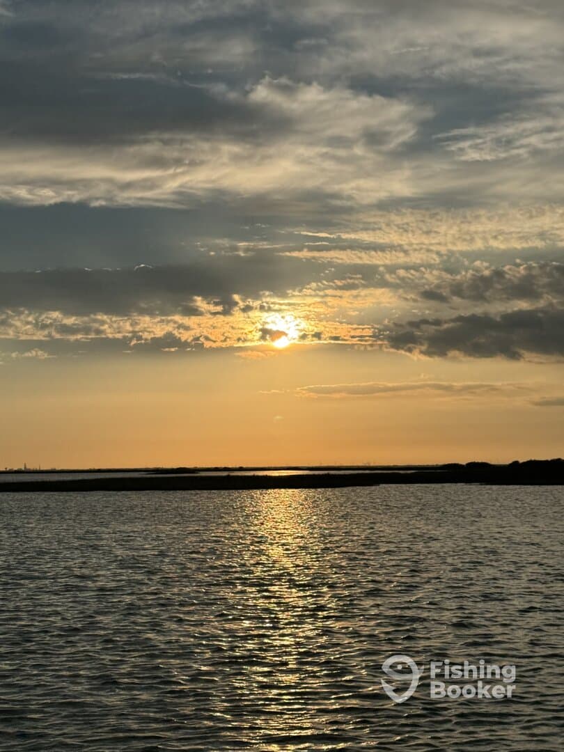 A scenic sunset over calm waters, capturing the tranquil beauty of the fishing environment.