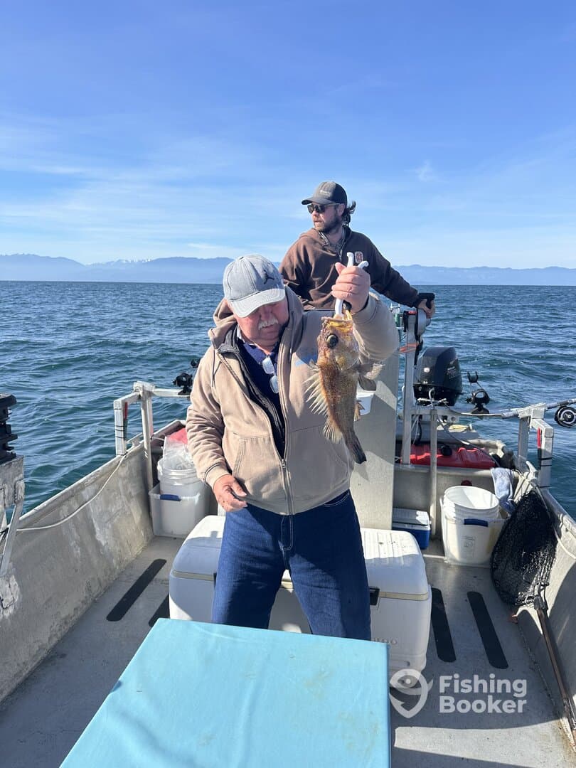 An angler proudly displaying a large fish while fishing from a boat in open waters, showcasing a beautiful day on the water.