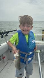 A young angler proudly displaying a caught fish while enjoying a day on the water.