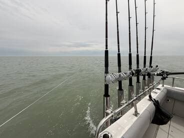 View of the boat's interior with fishing rods set up, ready for a day of deep-sea fishing in open waters.