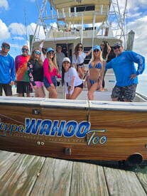 A lively group poses on the deck of the 'Cappa Wahoo Too' in Islamorada, Florida Keys, showcasing the vibrant atmosphere of a fishing charter.