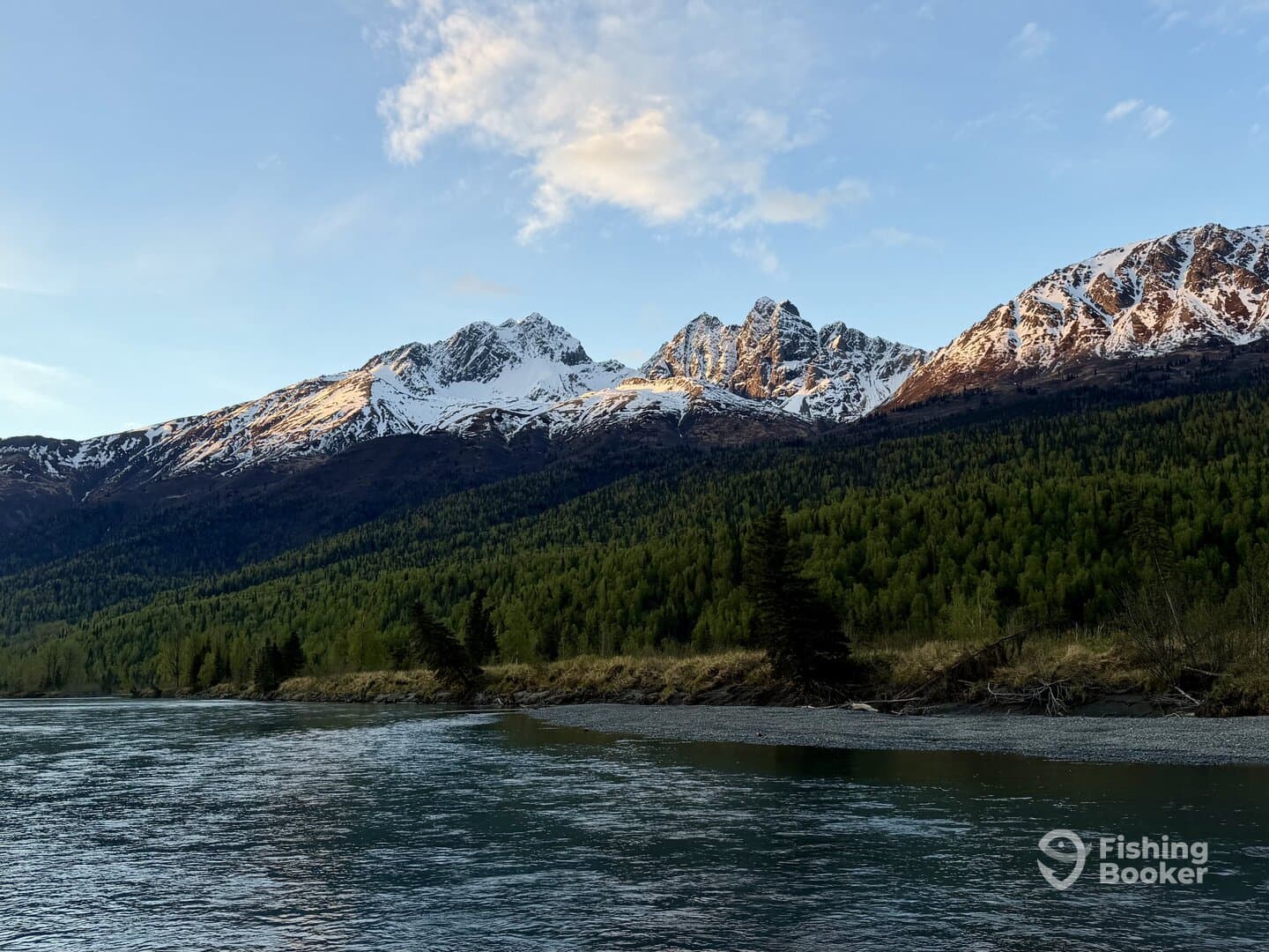 Scenic view of snow-capped mountains and a river, showcasing the natural beauty of a fishing environment.