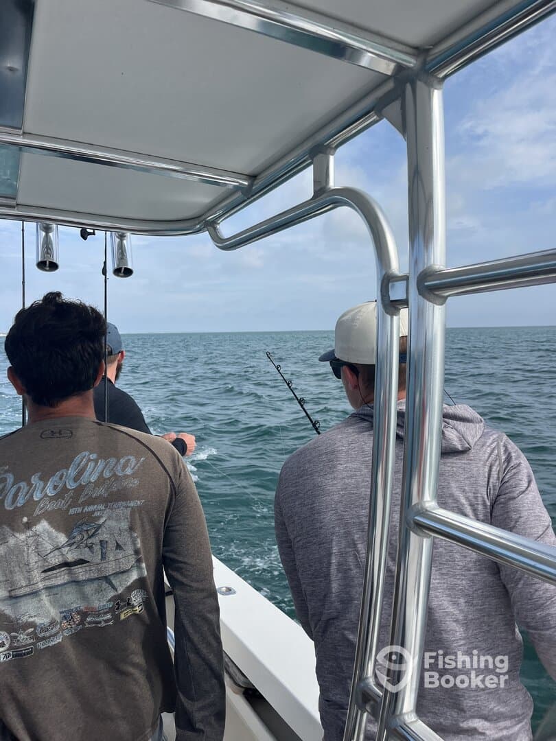Anglers actively fishing on a boat, with rods in hand, enjoying a day on the water.