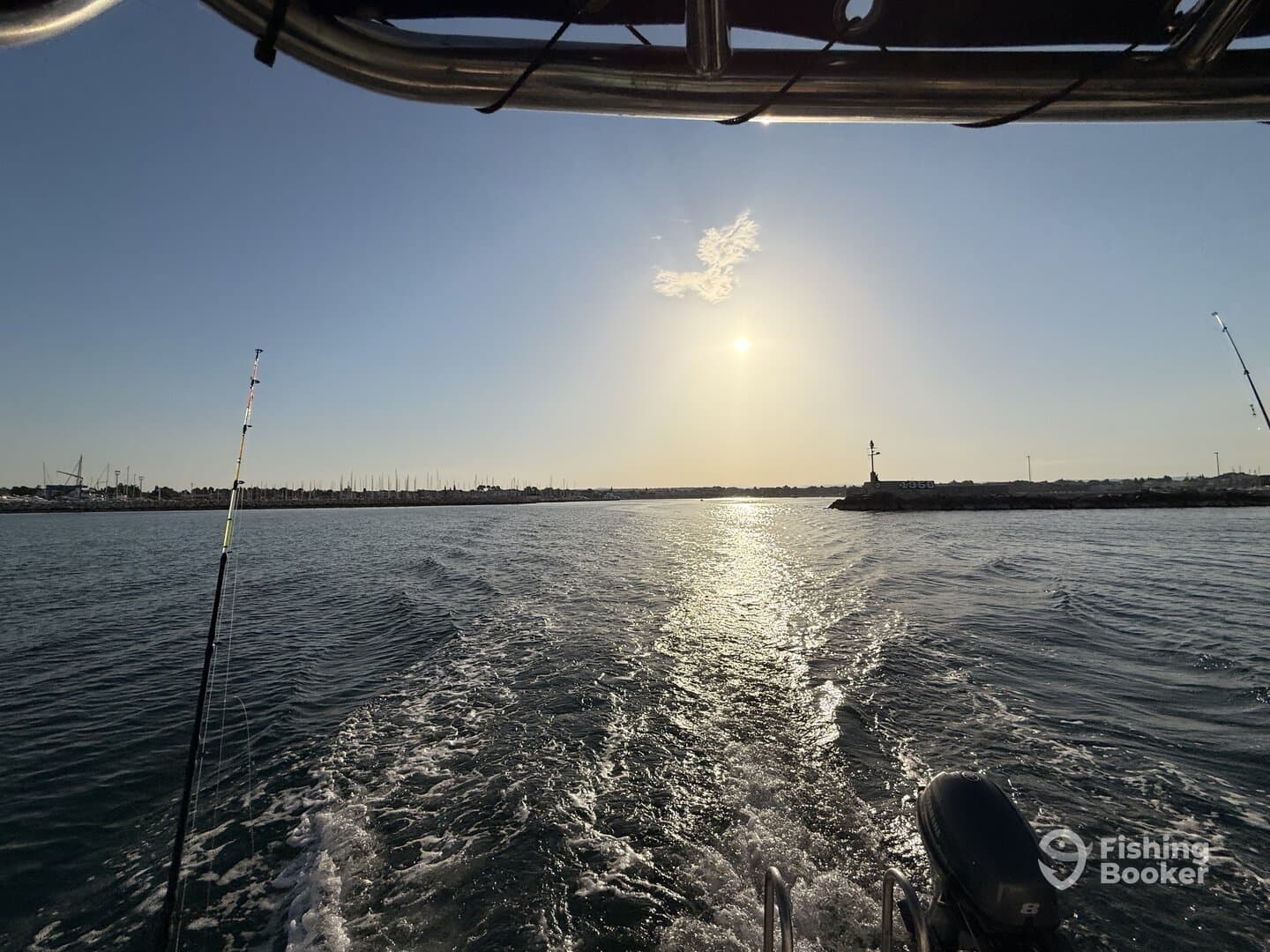 A scenic view from the boat as it heads out to sea, showcasing the calm waters and a beautiful sunset.