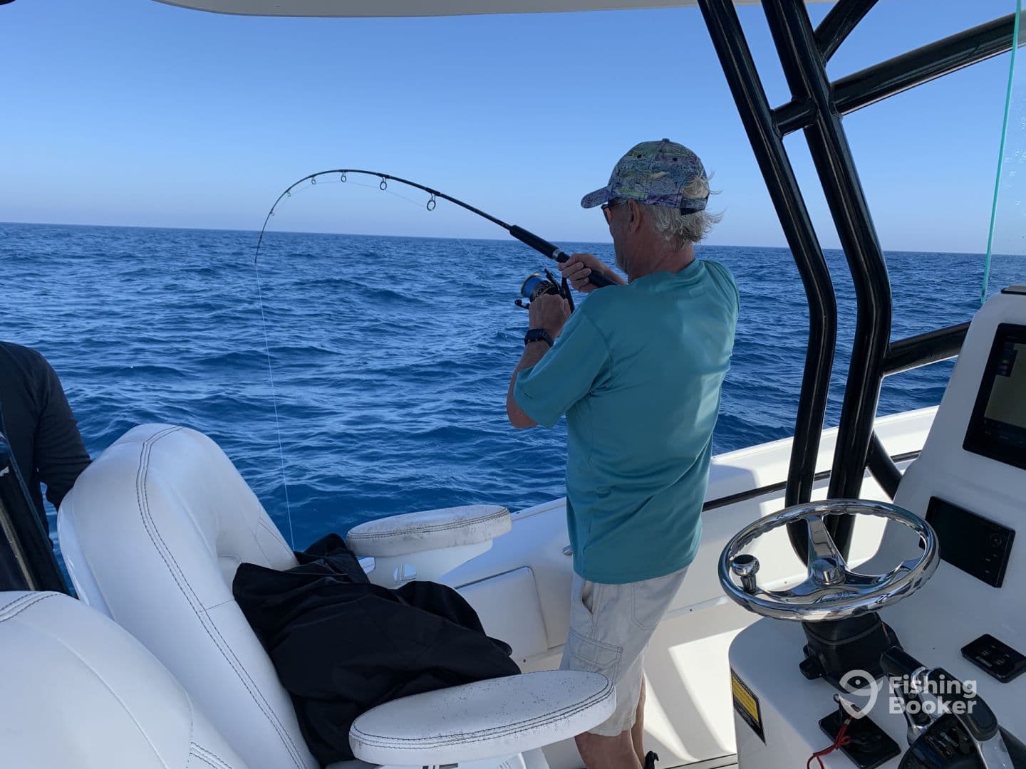 An angler reeling in a catch while fishing offshore, showcasing the excitement of deep-sea fishing.