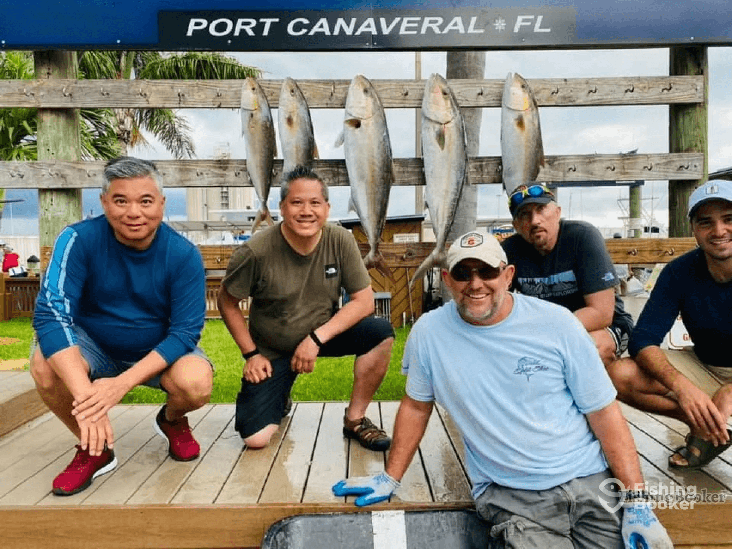 Group of anglers posing with their catch of several large fish displayed on a board at Port Canaveral, showcasing a successful fishing trip.