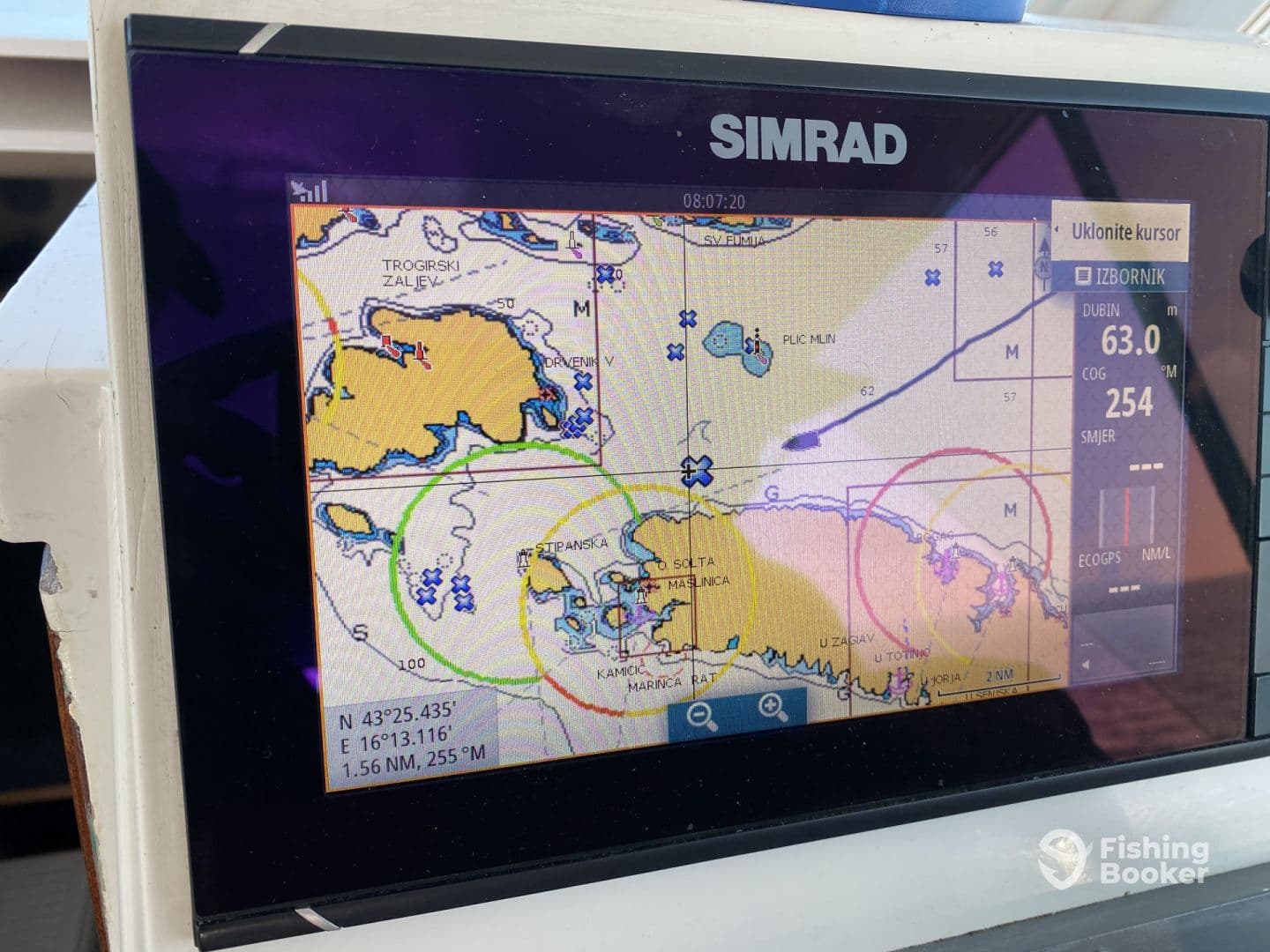 Close-up of a SIMRAD navigation display showing detailed marine charts and GPS information, ideal for navigating fishing spots.