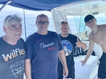 Group of four individuals enjoying their time inside a fishing boat, showcasing a relaxed atmosphere on the water.