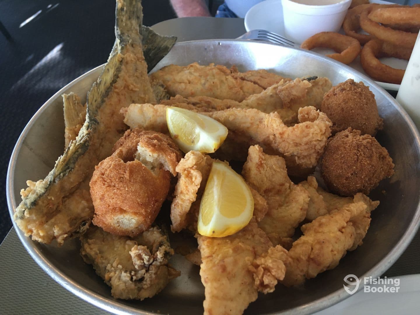 A platter of fried fish and sides, showcasing a variety of seafood dishes, likely enjoyed after a fishing trip.
