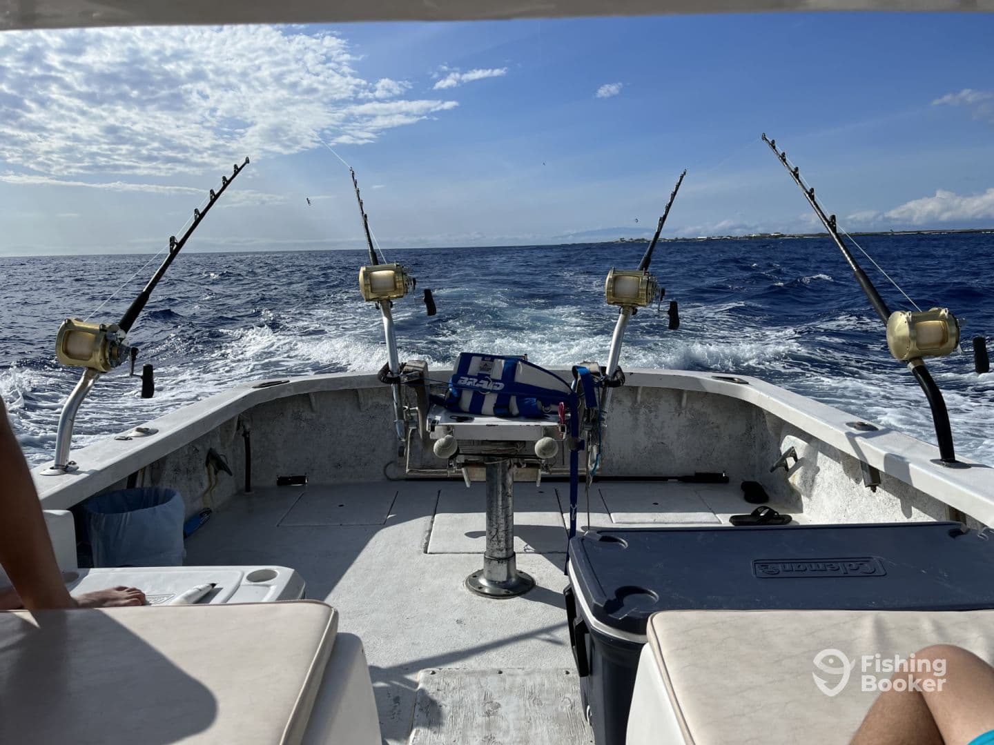 Interior view of a fishing boat with multiple rod holders and a clean helm area, showcasing a sunny day on the water.