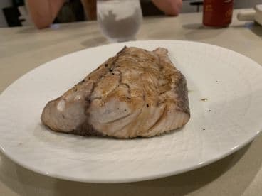 Grilled fish fillet presented on a plate, showcasing a delicious meal after a successful fishing trip.