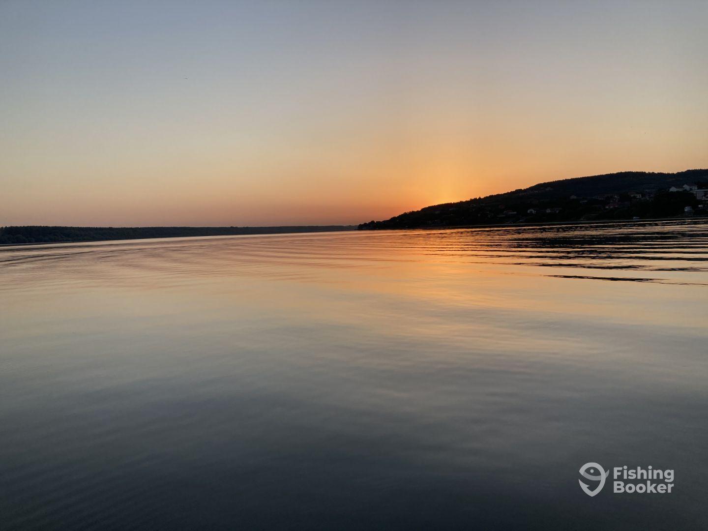 A serene sunset over calm waters, showcasing the tranquil fishing environment.