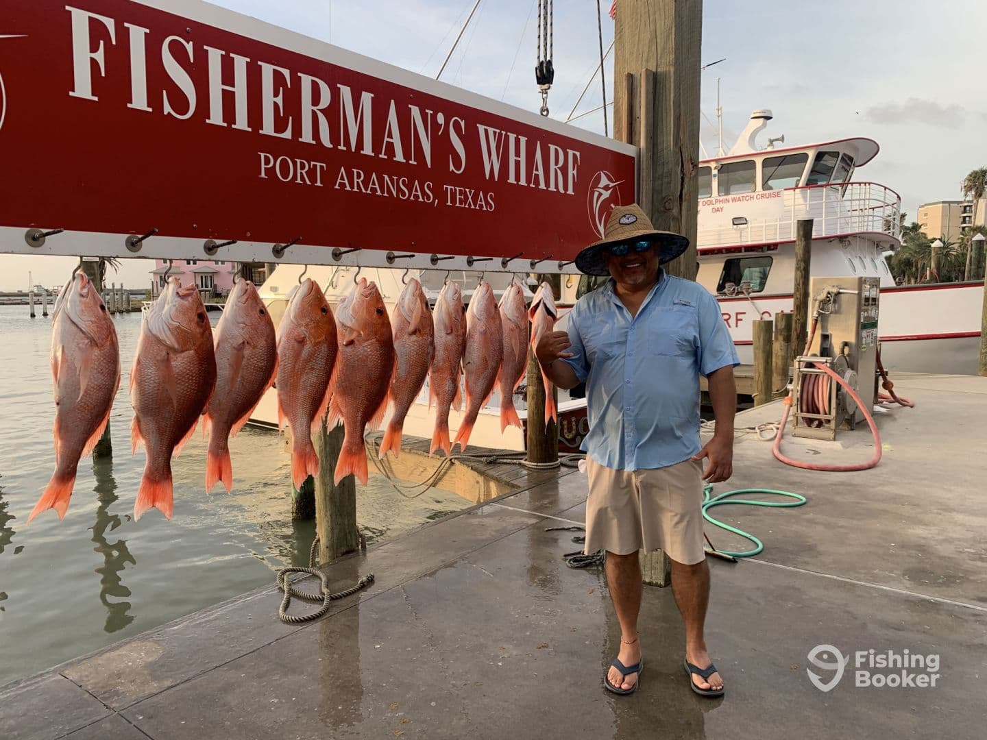 A satisfied angler poses with a display of freshly caught Red Snapper at Fisherman's Wharf in Port Aransas, Texas.