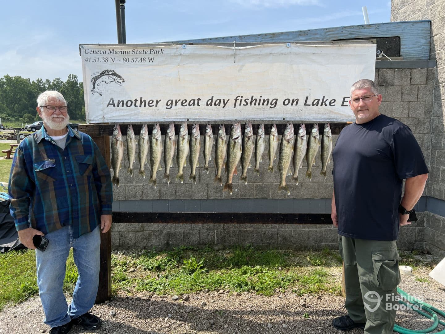 Two anglers proudly standing beside a catch board displaying multiple Walleye at Geneva Marina State Park, showcasing a successful fishing day on Lake Erie.