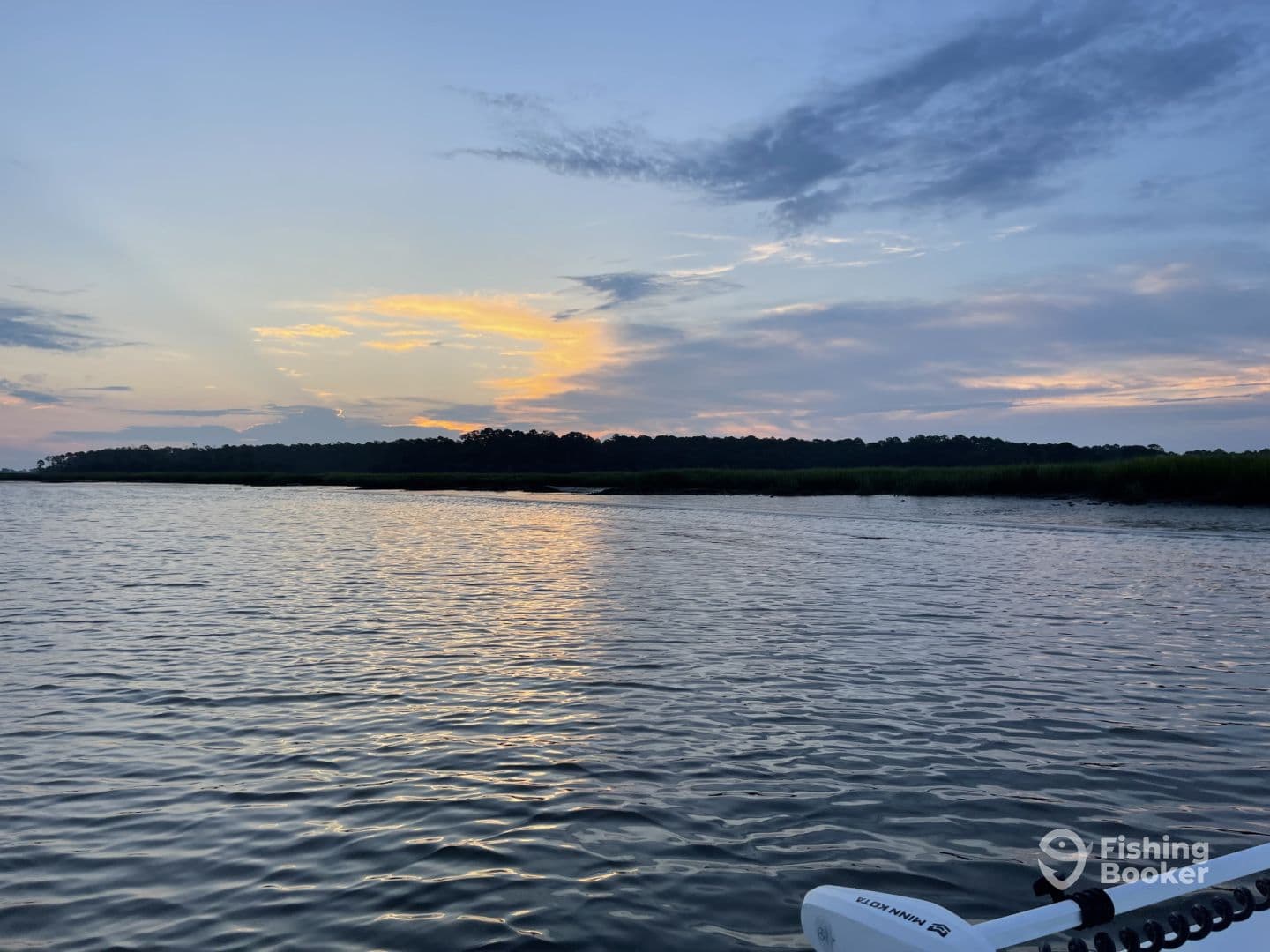 A serene sunset view over calm waters, showcasing the natural beauty of the fishing environment.