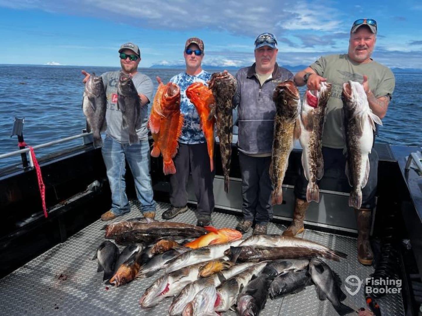 Four anglers proudly displaying their catch of various fish, including large rockfish and cod, on a fishing charter in open waters.