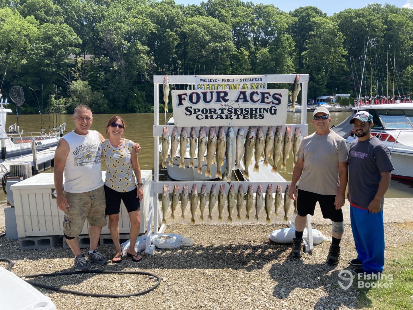 Group of four anglers proudly posing with their catch of Walleye displayed on a board at a fishing charter location.